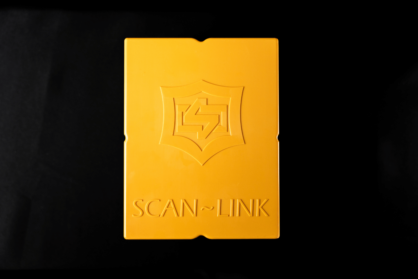 Black Scan-Link device with a circular green light display, red button, and cable.