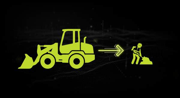 A loader reversing towards a worker