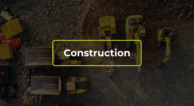 Aerial view of a construction site with yellow machinery and the word “Construction” overlaid.