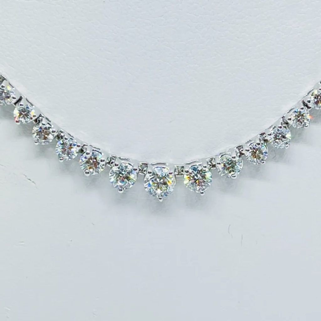 Silver rhinestone necklace with teardrop crystals on a white background