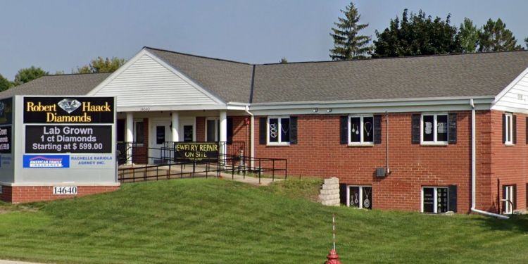 Brick office building with a sign for Robert J. Haskell Insurance and manicured lawn