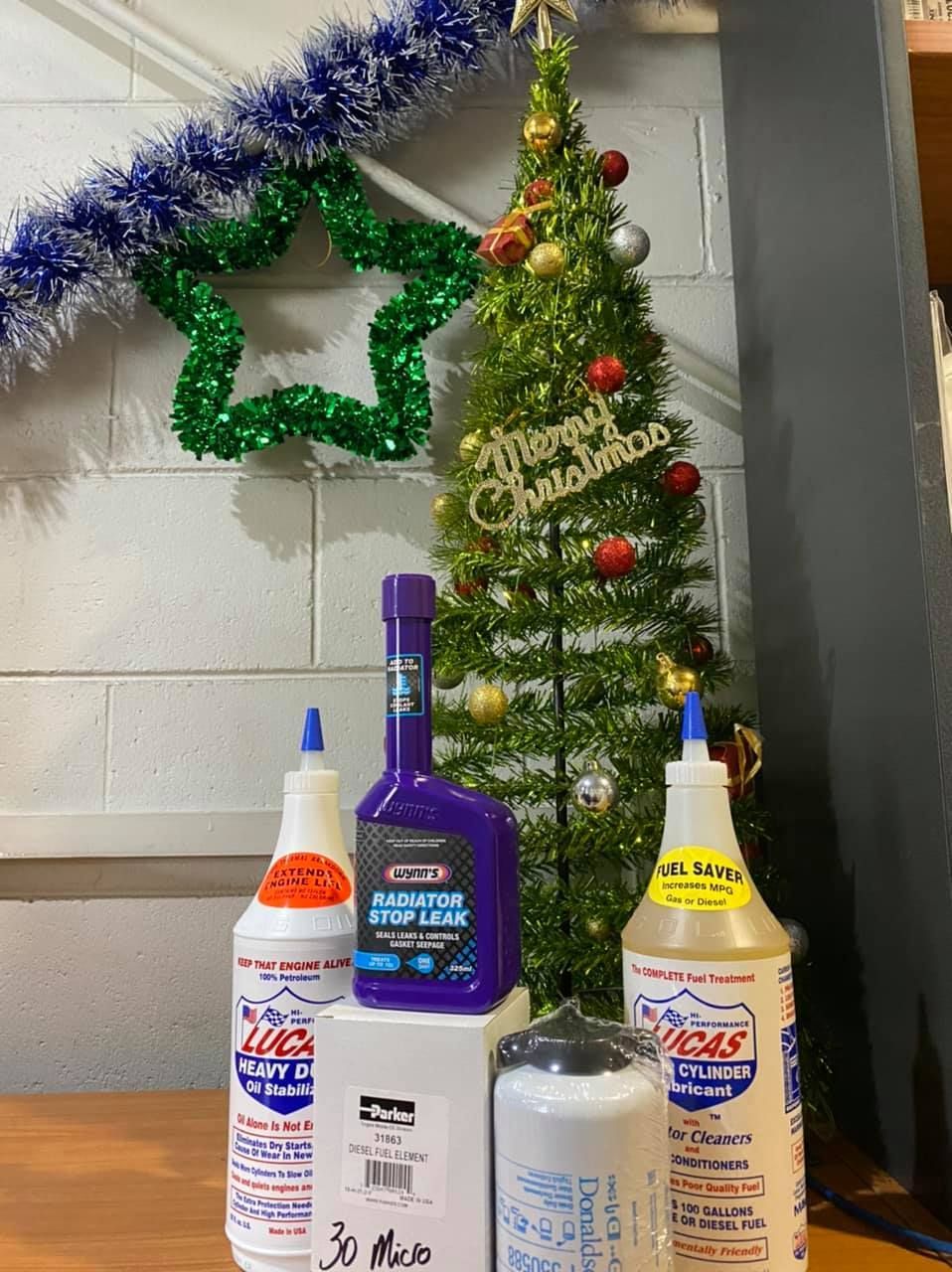A Christmas Tree Is Behind A Table With Bottles Of Cleaning Products — Filta-Wash Mackay In North Mackay, QLD