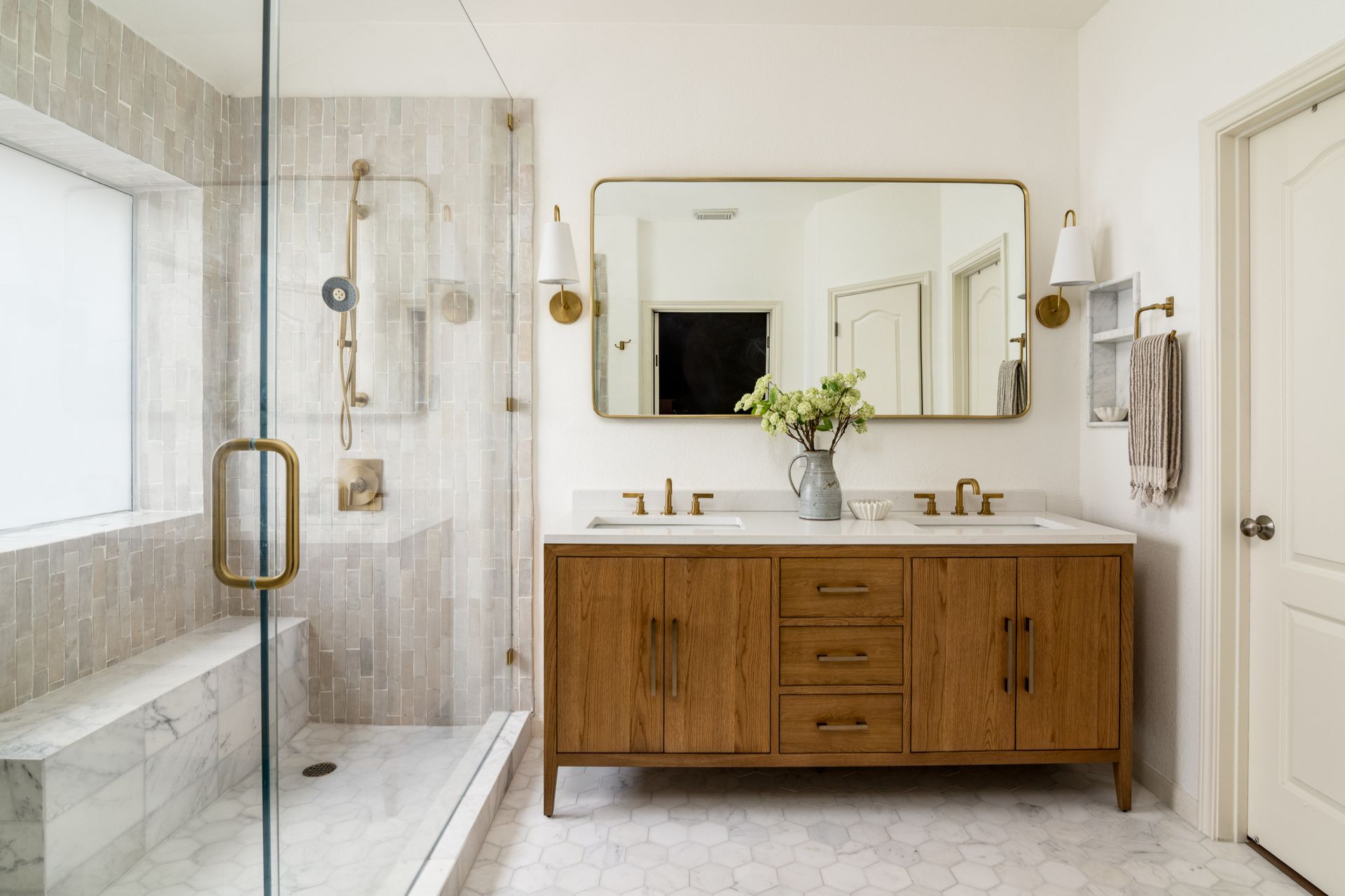 Modern bathroom with glass shower, wood vanity, and large mirror