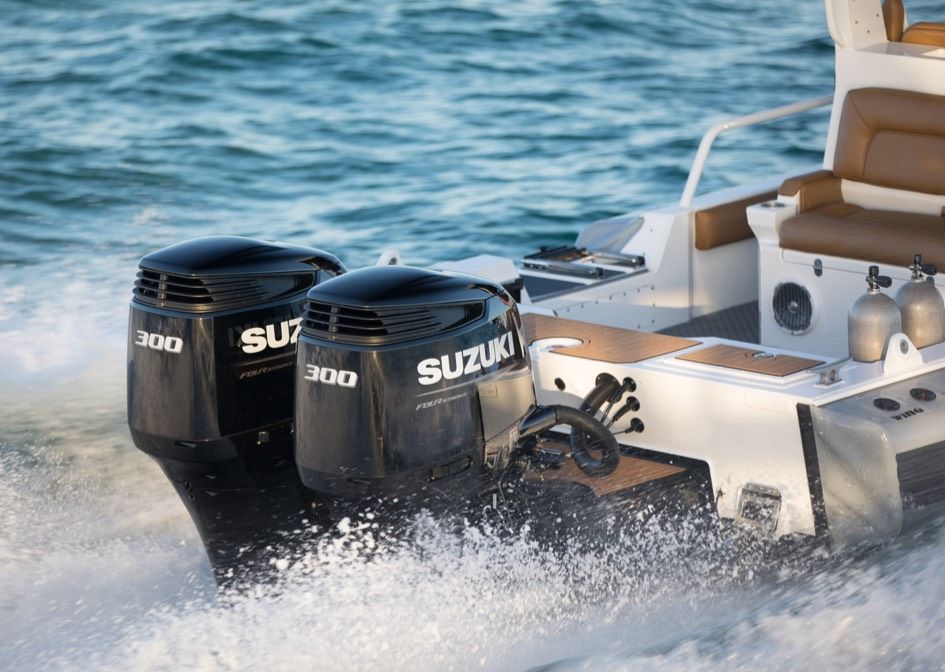 A suzuki boat is floating on top of a body of water.