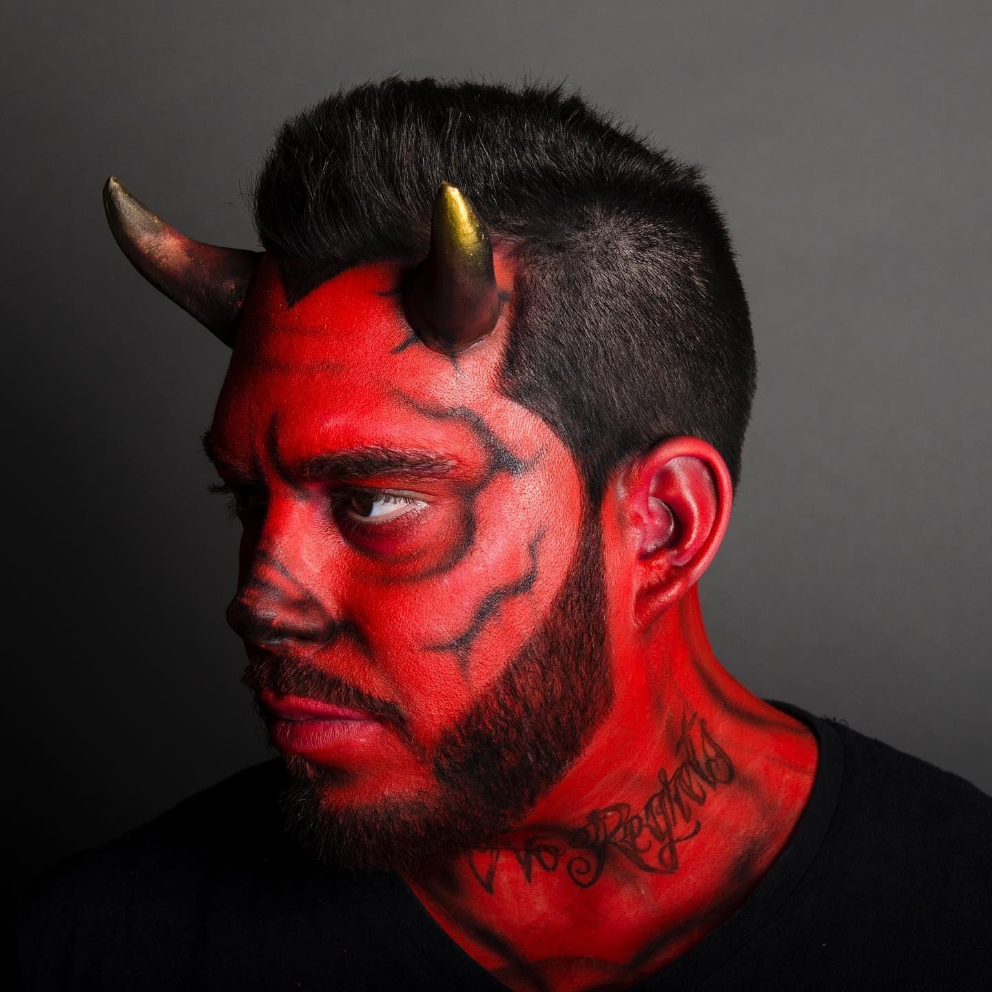 A man with red face paint and horns on his head.