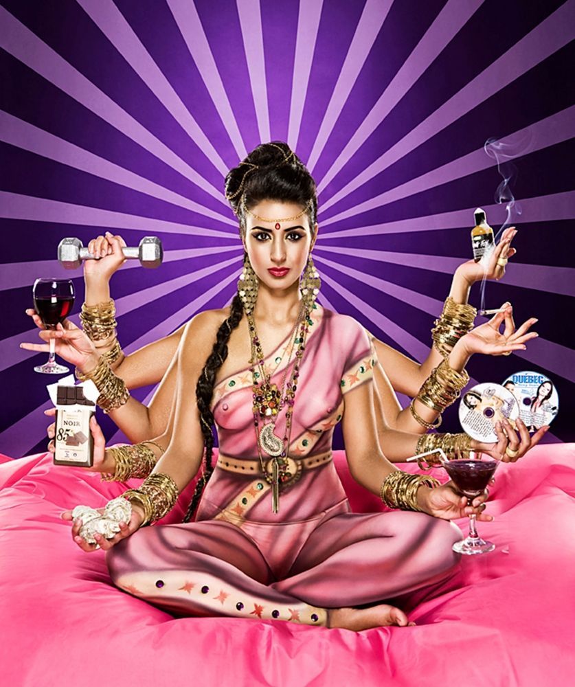 A woman with many hands is sitting on a bed