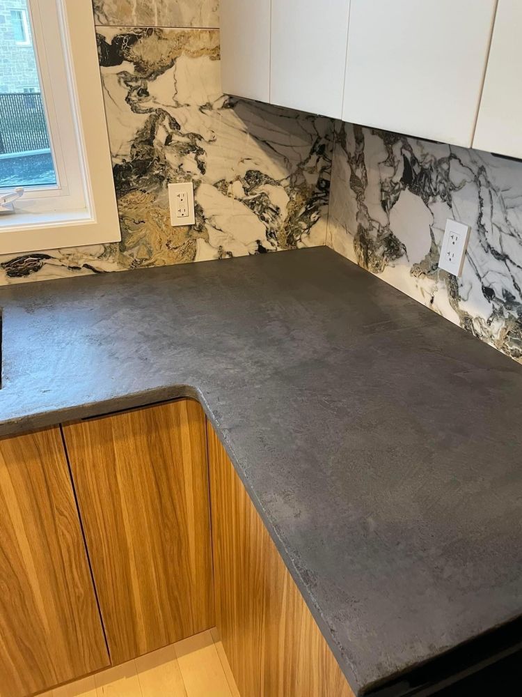 A kitchen with a black counter top and wooden cabinets.