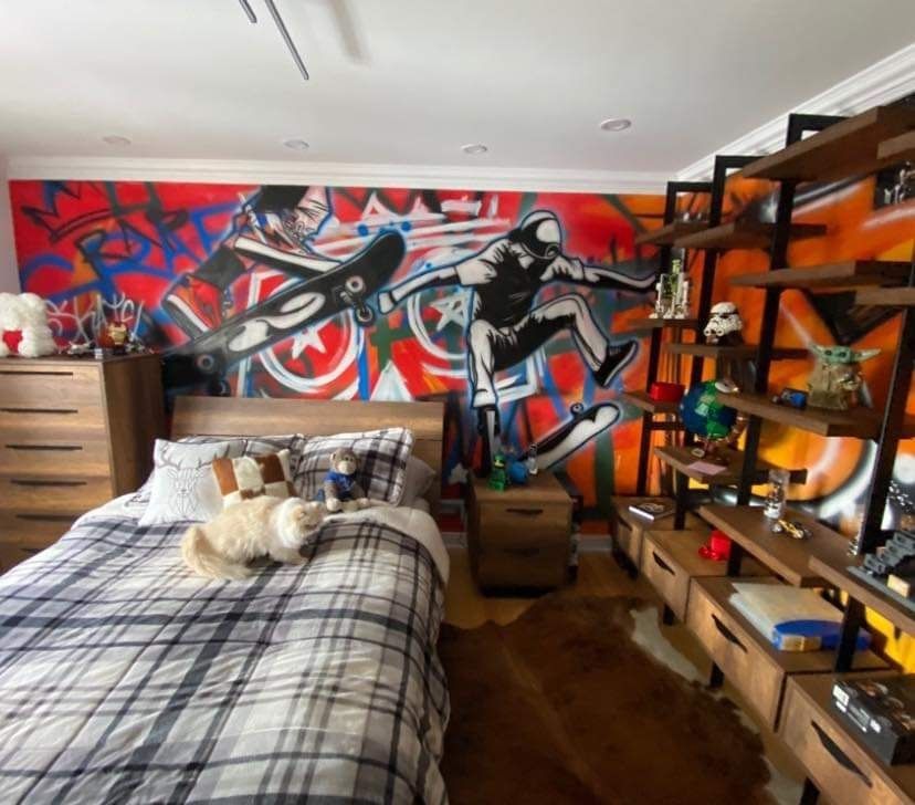 A bedroom with a mural on the wall and a bed