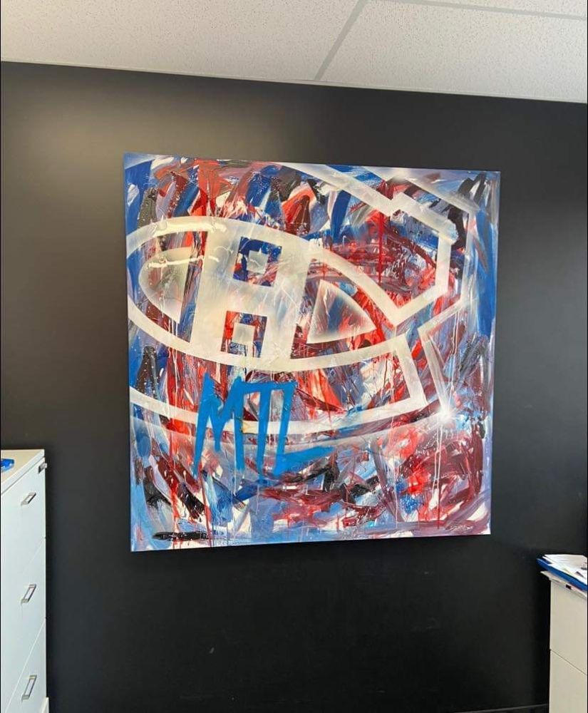 A painting of the canadiens logo hangs on a wall