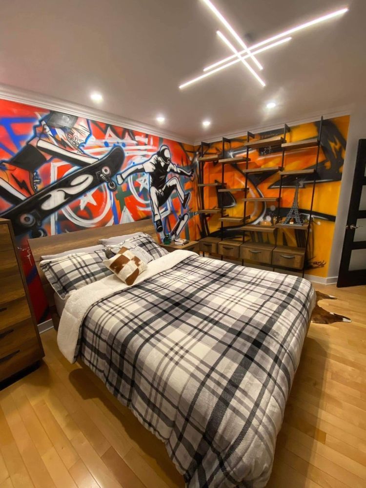 A bedroom with a bed and a mural on the wall.