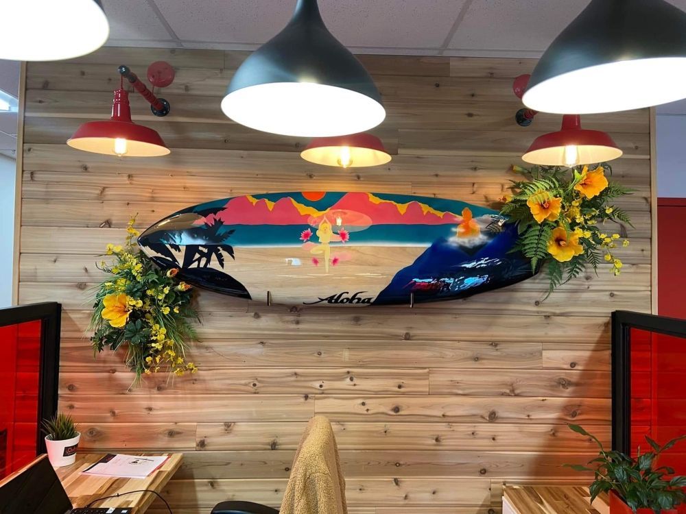 A wooden wall with a painting of a surfboard on it.