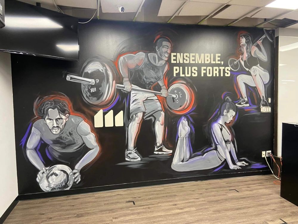 A mural of a man lifting a barbell and a woman doing push ups on a wall.