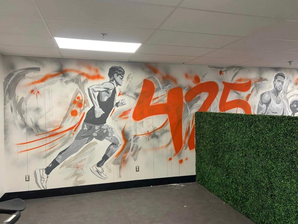 A wall with a painting of a man running and the number 425 on it.
