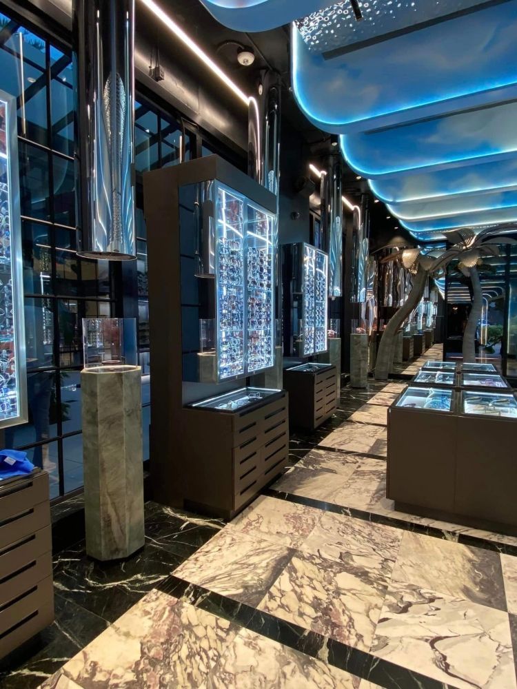 A long hallway with a marble floor and a lot of displays in a store.