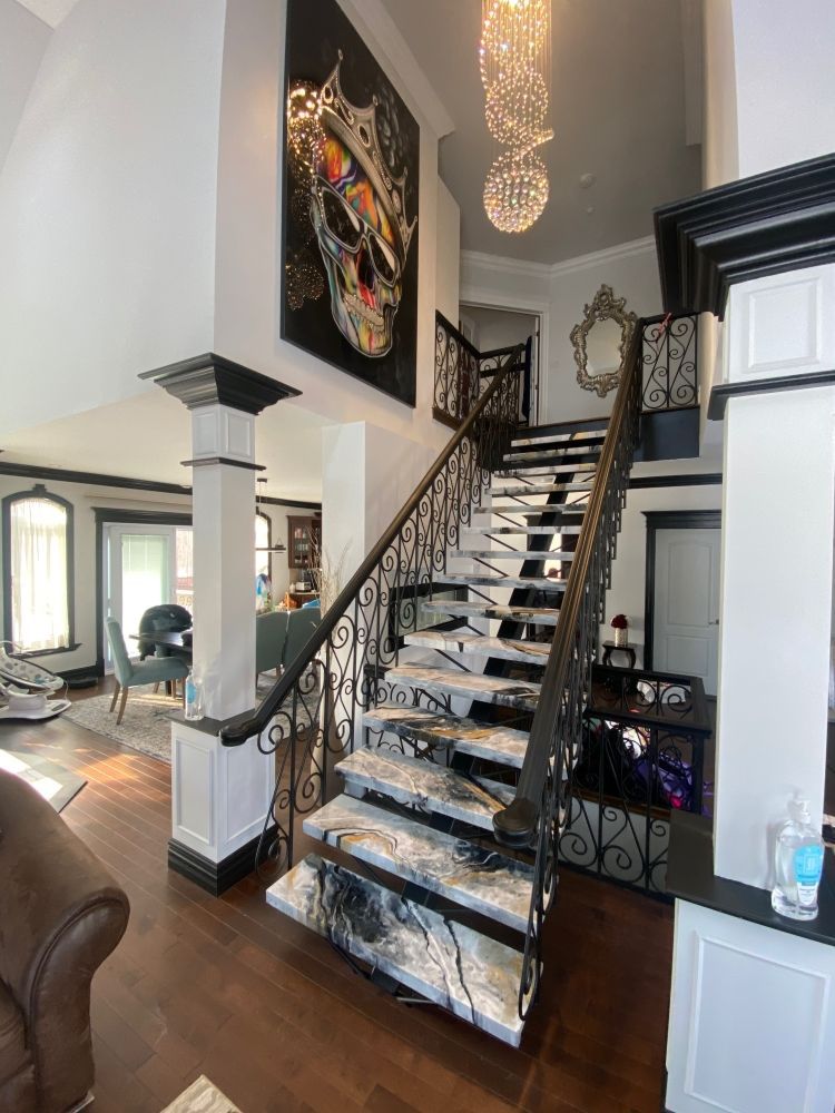 A living room with a staircase leading up to the second floor.