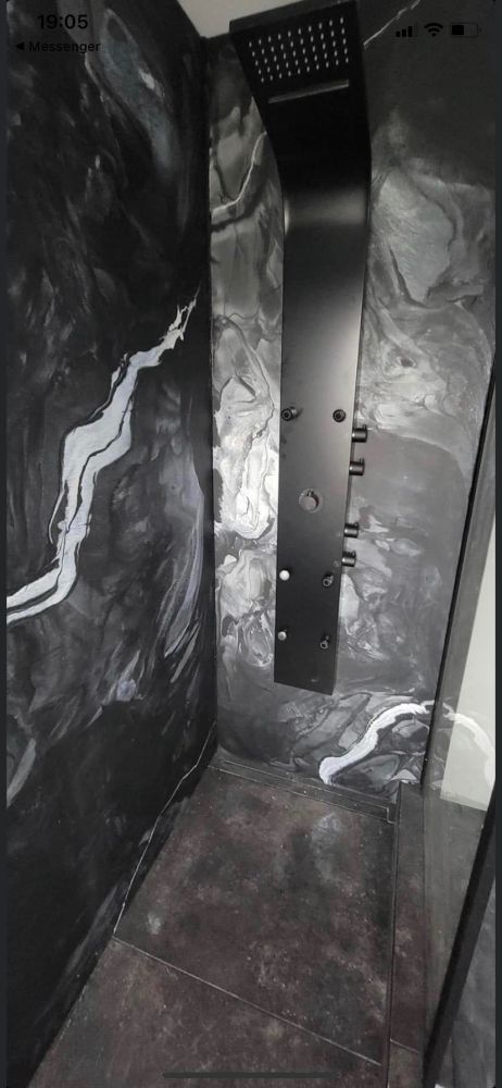 A black and white photo of a shower with a black shower head.