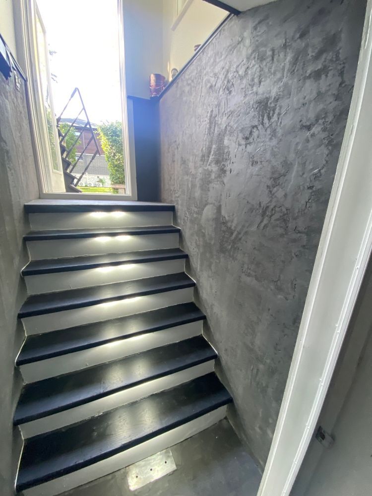 A set of stairs leading up to a concrete wall.