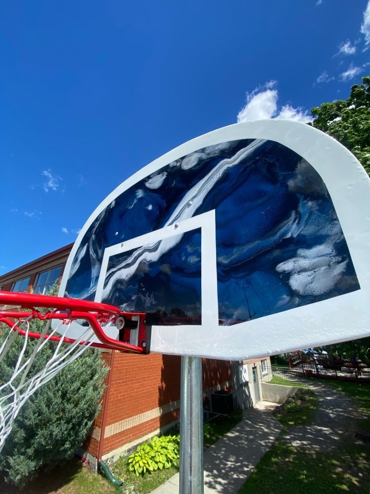 A basketball hoop is sitting in front of a brick building.