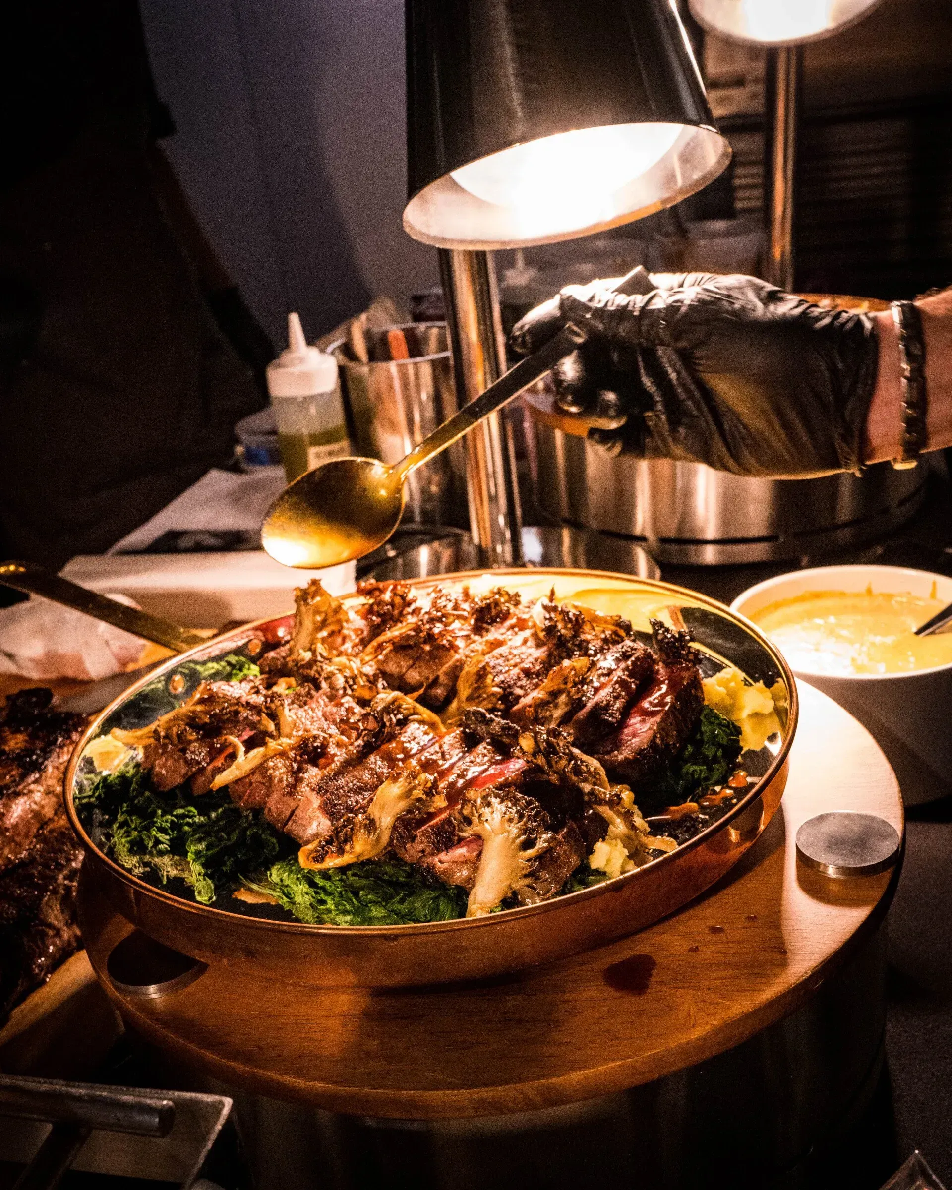 A person is pouring sauce on a plate of food.