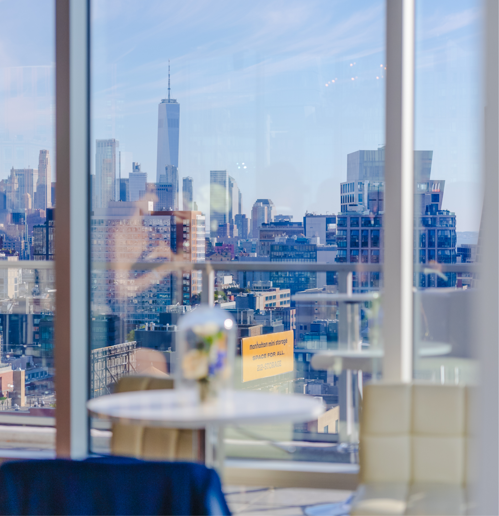 A person is taking a picture of a city skyline through a window.