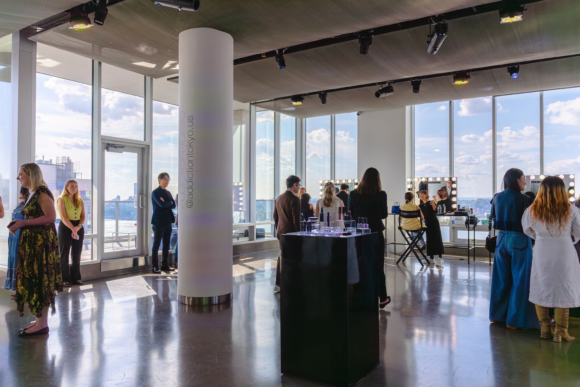 a group of people are standing in a large room with a lot of windows .