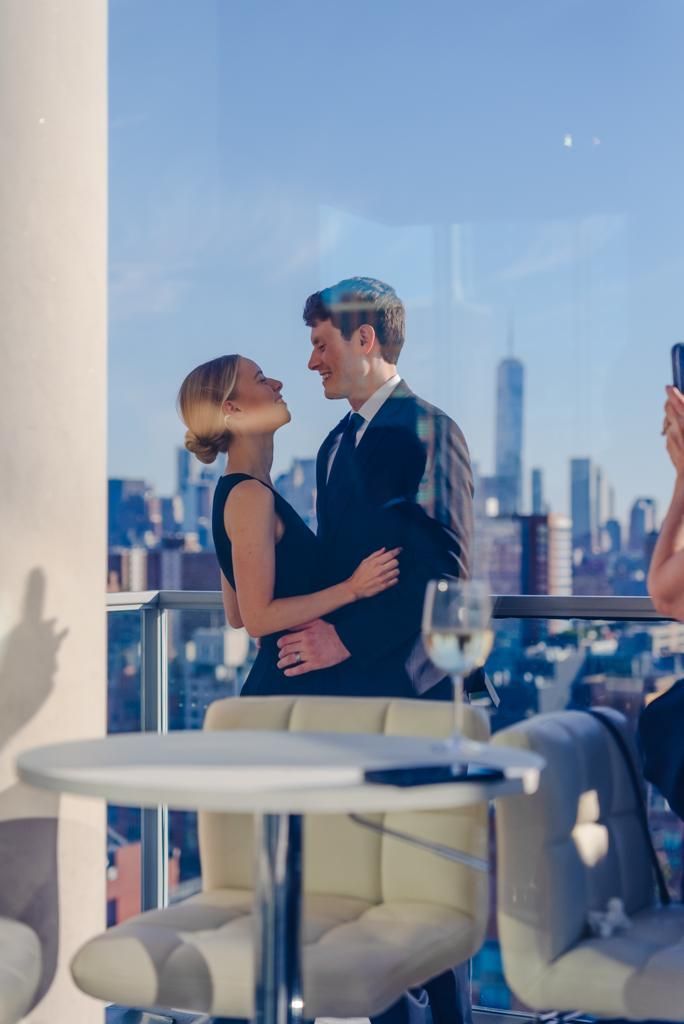 A man and a woman are standing next to each other on a balcony.