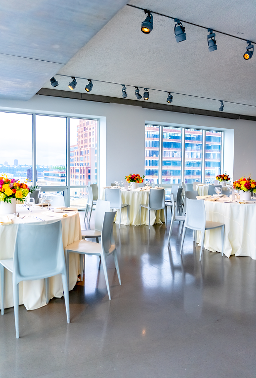 A large room with tables and chairs set up for a party.