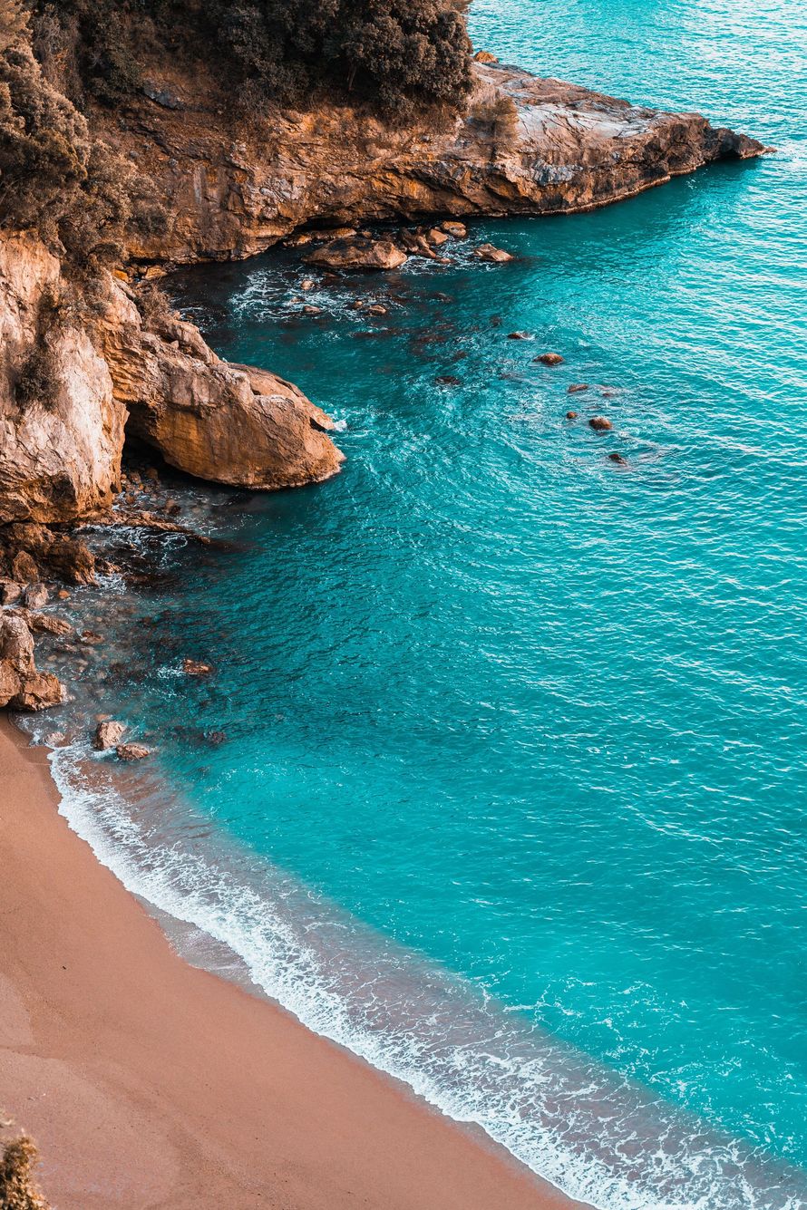 Turquoise cove with rocky cliffs and a sandy beach shoreline