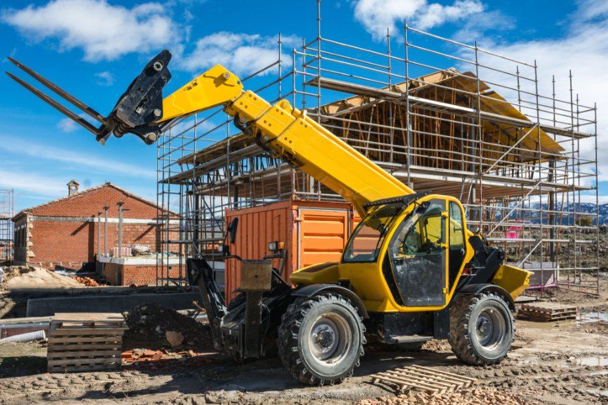 A Yellow Forklift is Parked in Front of a Building Under Construction — Byron Bay Scaffold in Burleigh Heads, QLD