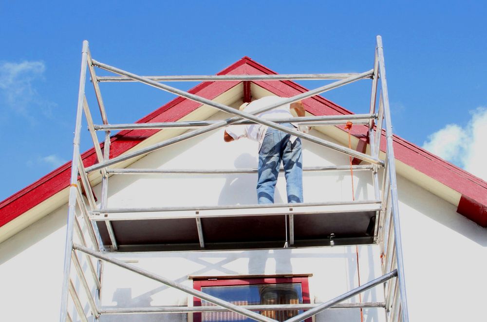 A Man is Painting the Side of a House on a Scaffolding — Byron Bay Scaffold in Kinvara, NSW