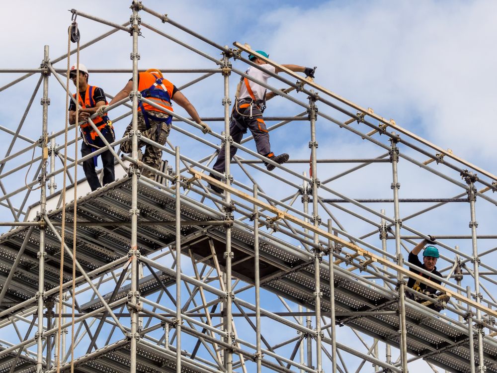 A Group of Construction Workers Are Working on a Scaffolding Structure — Byron Bay Scaffold in Kinvara, NSW
