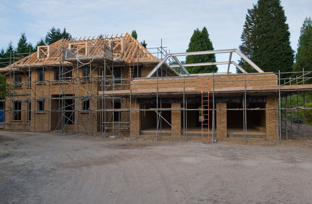 A Large House Under Construction With Scaffolding Around It — Byron Bay Scaffold in Lennox Head, NSW