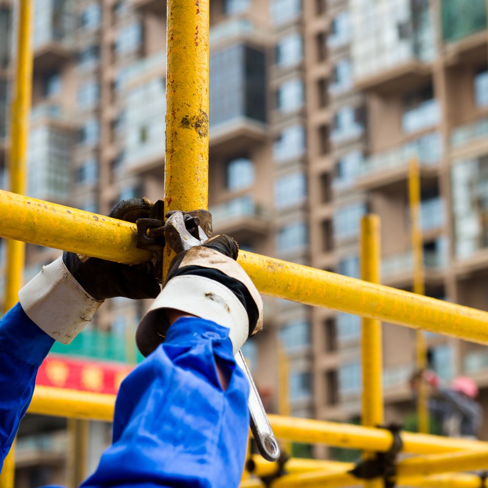 A Person Wearing Blue Gloves is Working on a Scaffolding — Byron Bay Scaffold in Tallebudgera, QLD