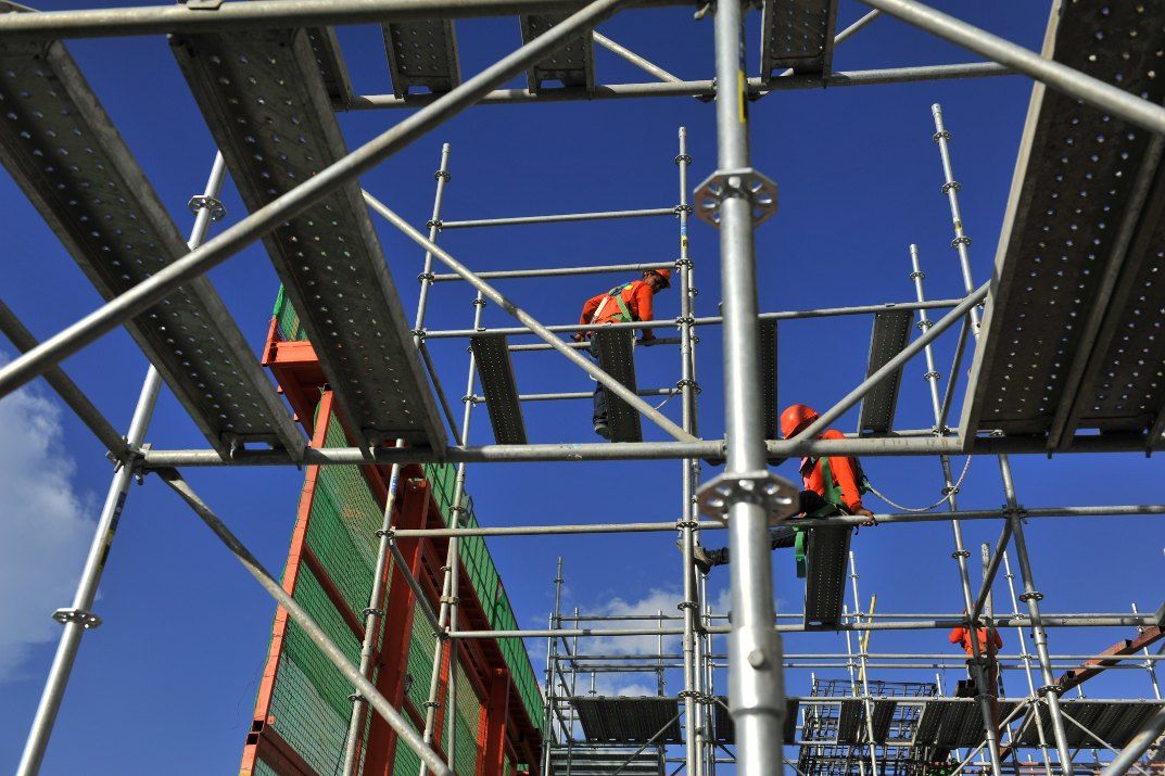 Three Construction Workers Are Working on a Scaffolding Structure — Byron Bay Scaffold in Tenterfield, NSW