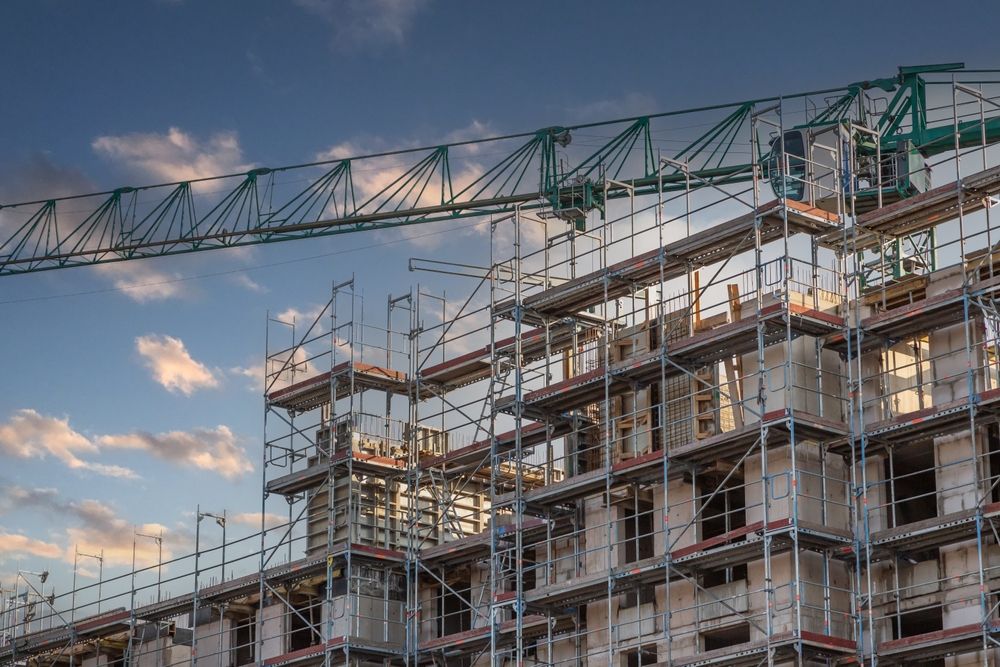 A Large Building Under Construction With Scaffolding and a Crane — Byron Bay Scaffold in Yamba, NSW
