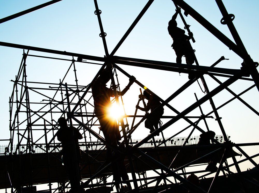 A Group of Construction Workers Are Working on a Scaffolding Structure — Byron Bay Scaffold in Coffs Harbour, NSW