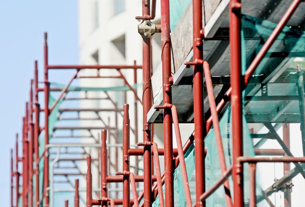 A Row of Red Scaffolding on a Building Under Construction — Byron Bay Scaffold in Kinvara, NSW