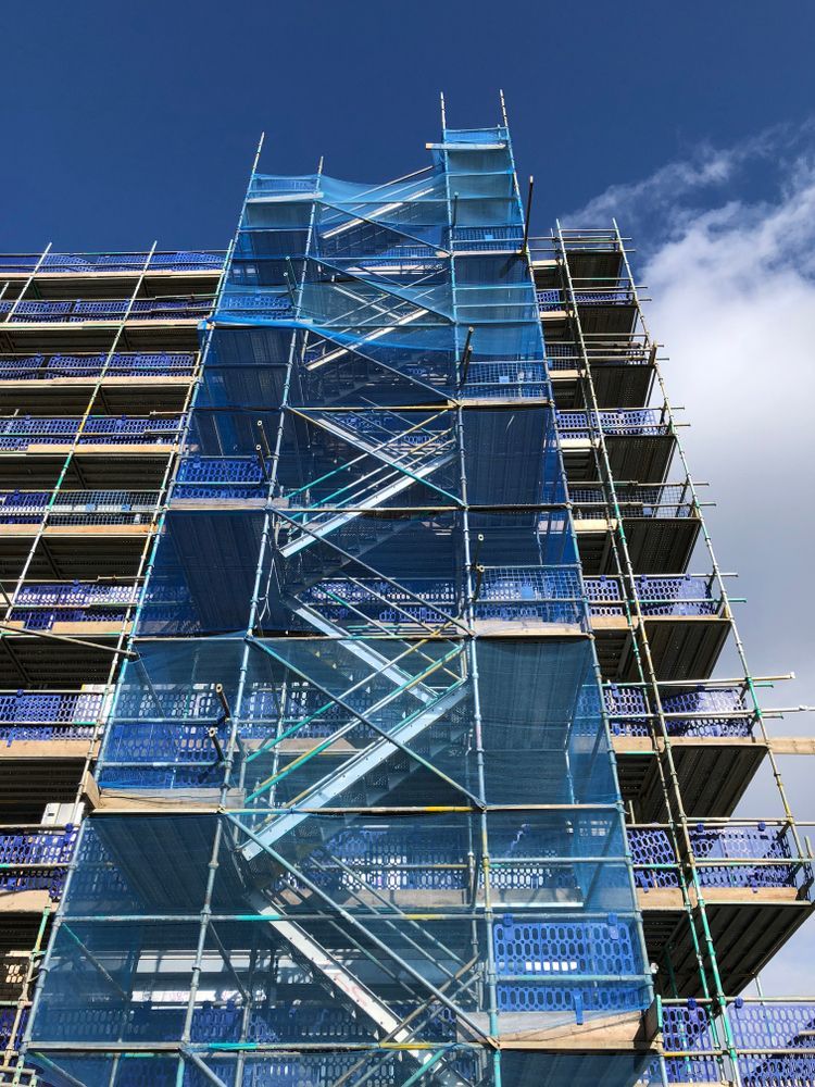 A Tall Building is Being Built With Scaffolding and Stairs — Byron Bay Scaffold in Kinvara, NSW