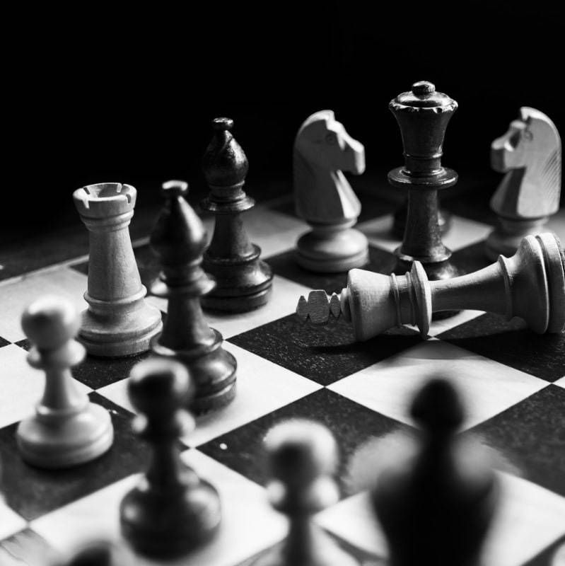A black and white photo of a chess board with pieces on it
