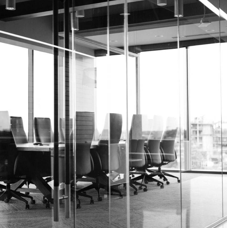 A black and white photo of a conference room with a glass wall