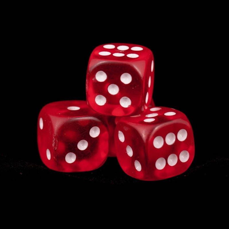 Three red dice are stacked on top of each other on a black background