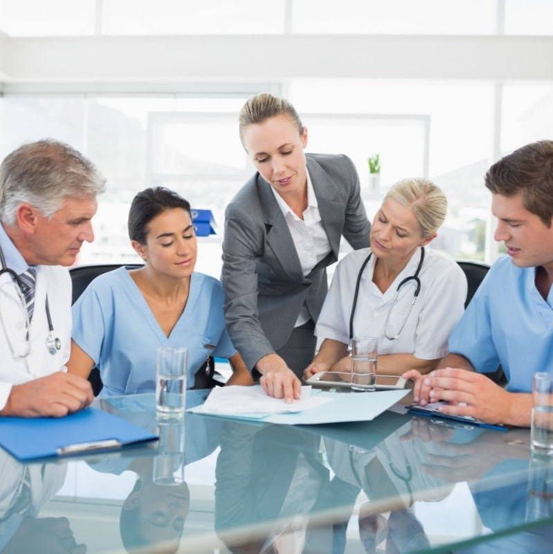 A group of doctors and nurses are sitting around a table