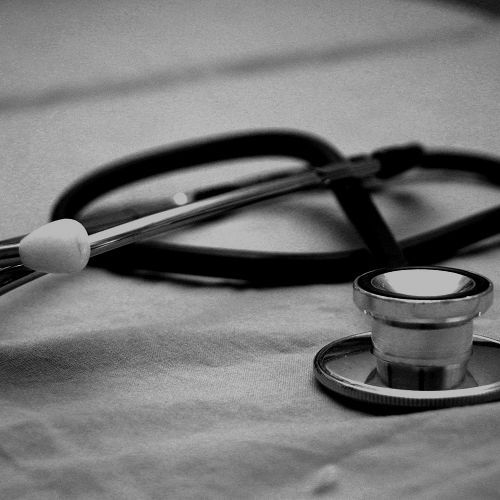 A black and white photo of a stethoscope on a table.