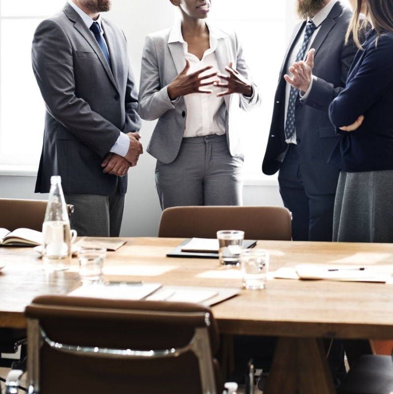 A group of people standing around a conference table