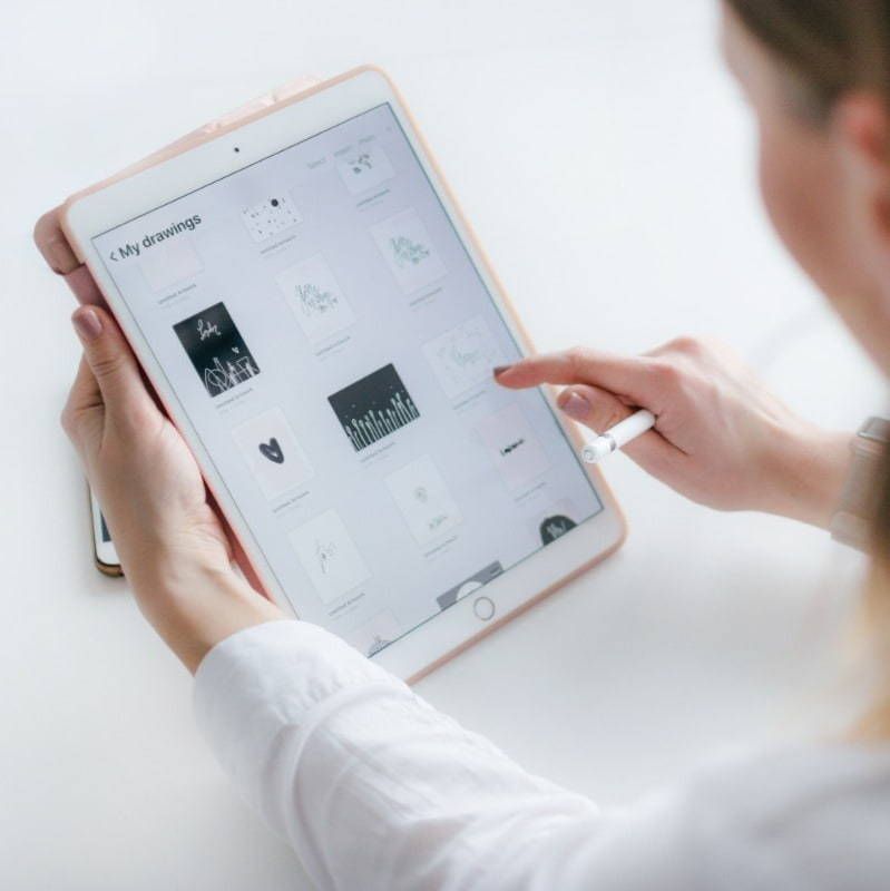 A woman is holding a tablet that says my branding on the screen