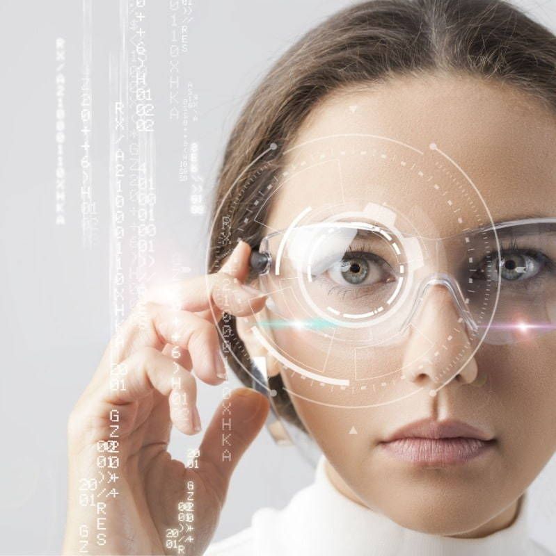 A woman wearing futuristic glasses looks at something