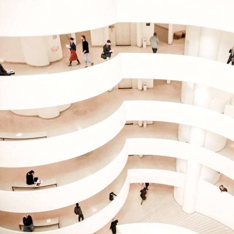 A group of people are walking down a spiral staircase in a building
