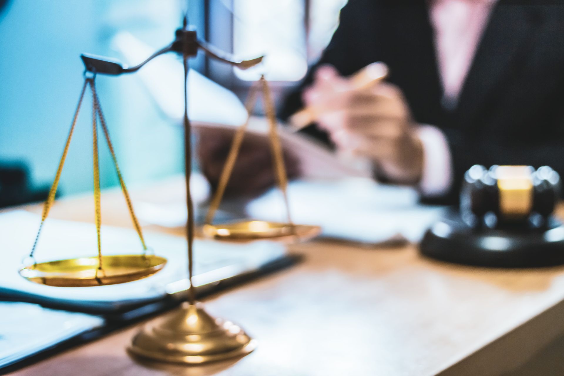 Lawyer’s desk with brass scales of justice and a gavel in the background