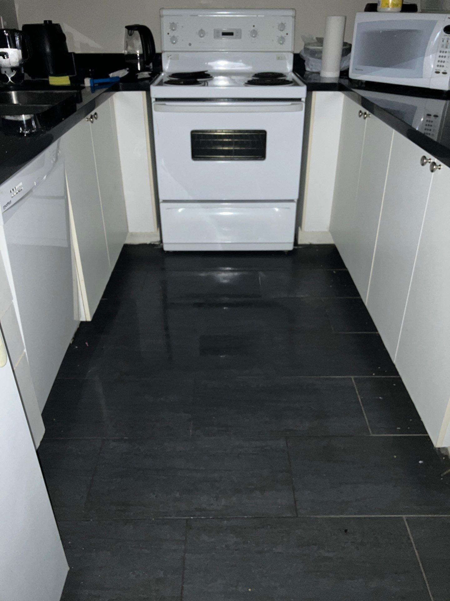 A kitchen with a stove and a microwave in it