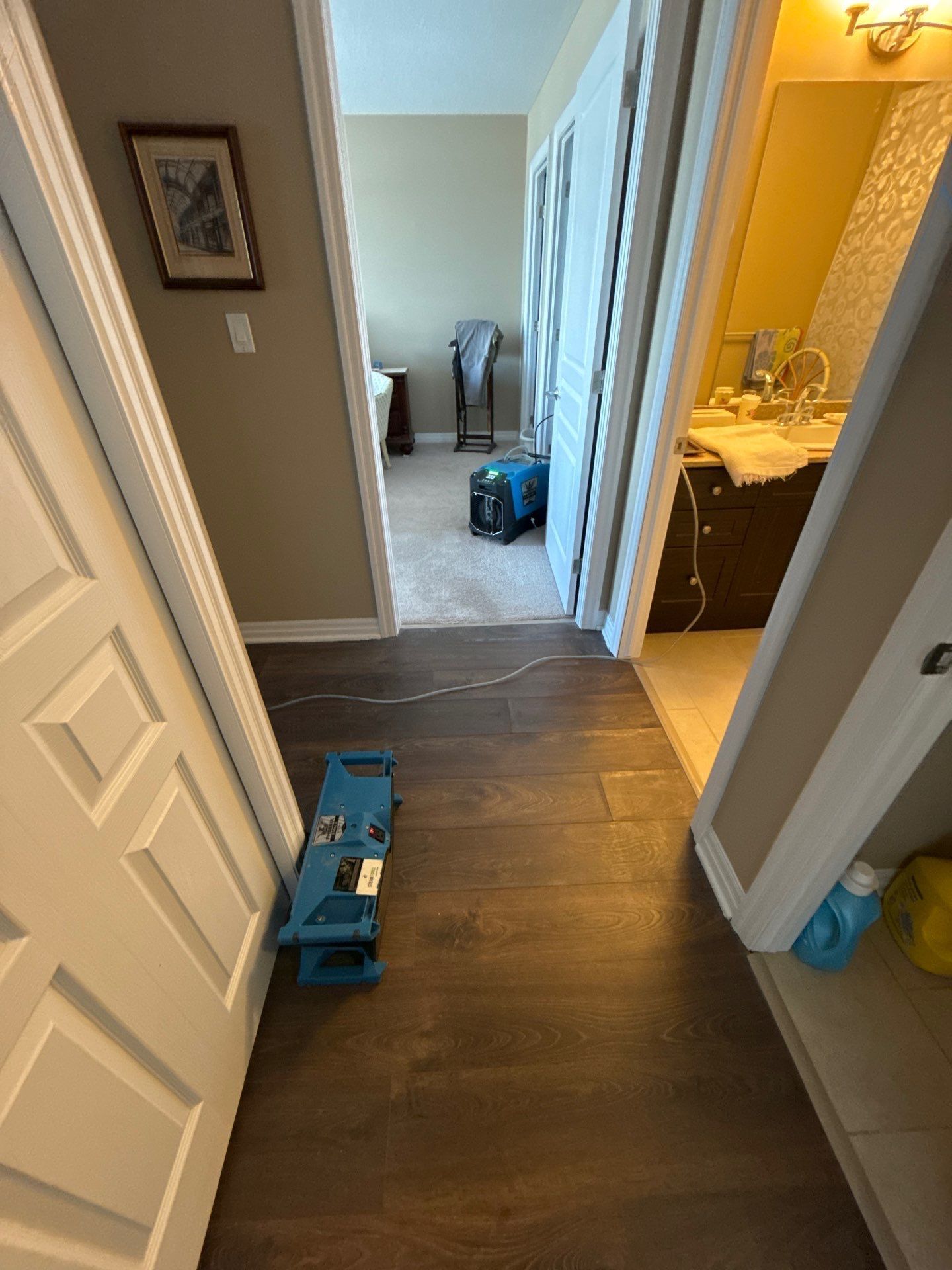 A hallway in a house with a blue stool on the floor.